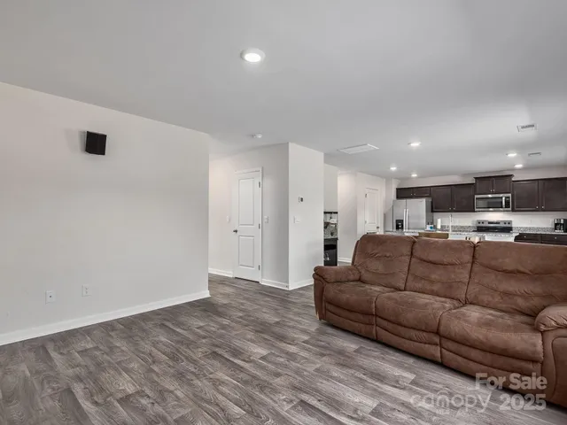 a living room with furniture and kitchen view