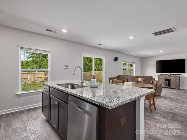 a kitchen with granite countertop kitchen island a sink and a stove