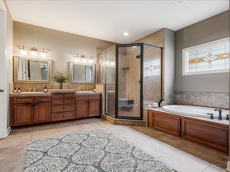 4597 Whisper Spring Drive Collierville, TN 38017 - Photo 17 of 39 a large bathroom with a double vanity sink a large mirror and a bathtub