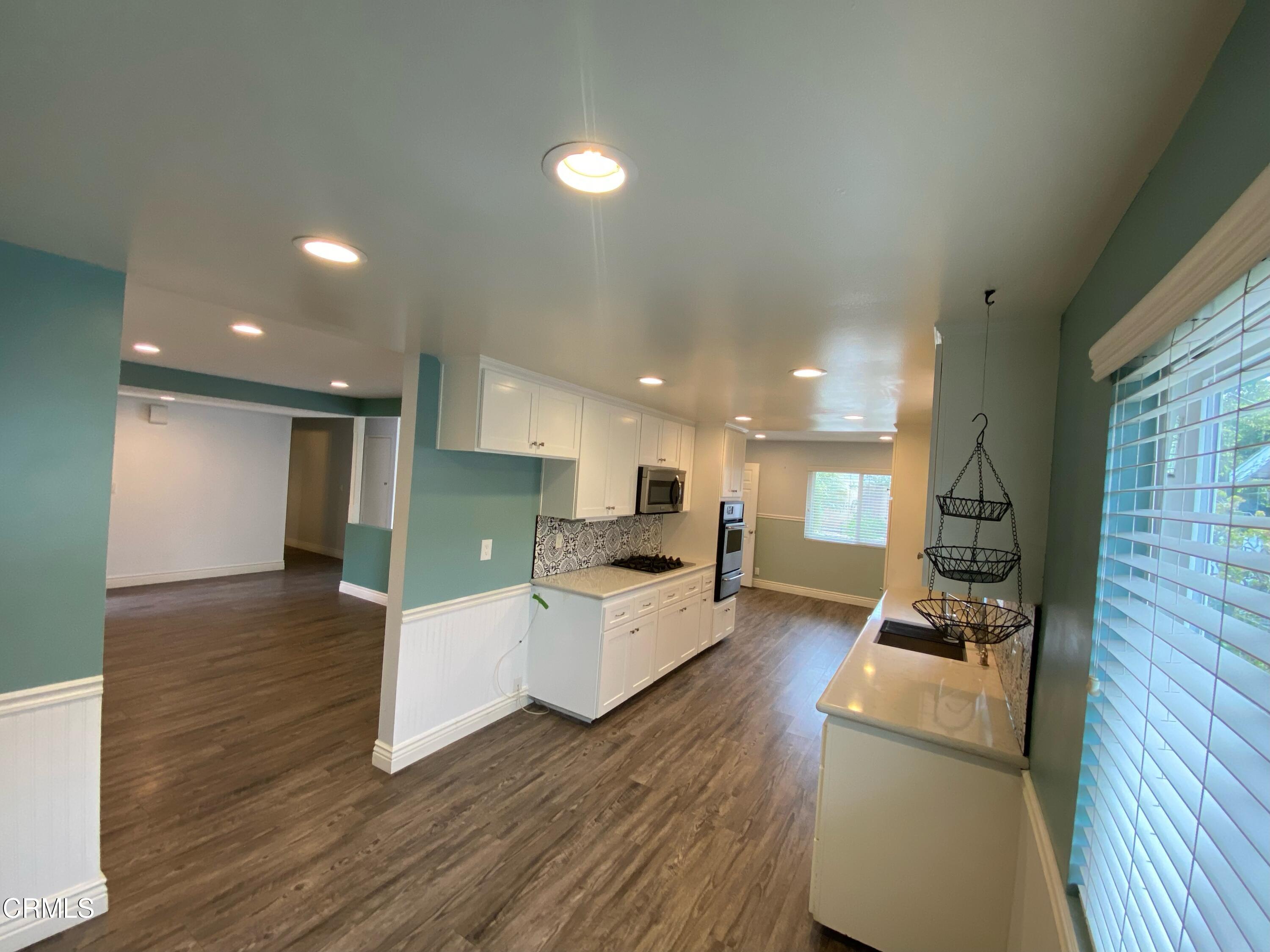 2046 Koala Way Ventura, CA 93003 - Photo 9 of 29 a large living room with stainless steel appliances furniture a flat screen tv and a fireplace