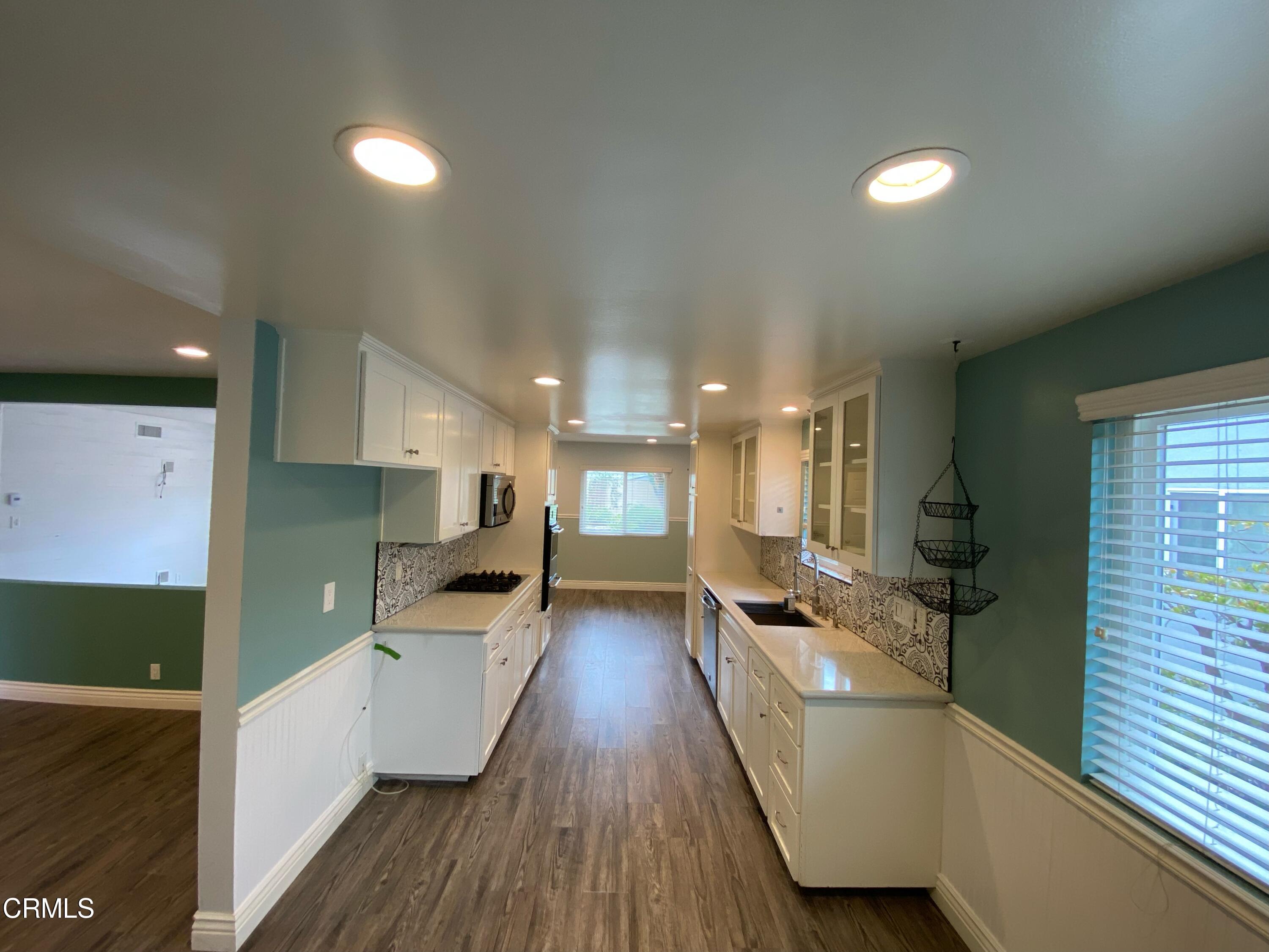 2046 Koala Way Ventura, CA 93003 - Photo 10 of 29 a view of a living room kitchen with a sink and wooden floor