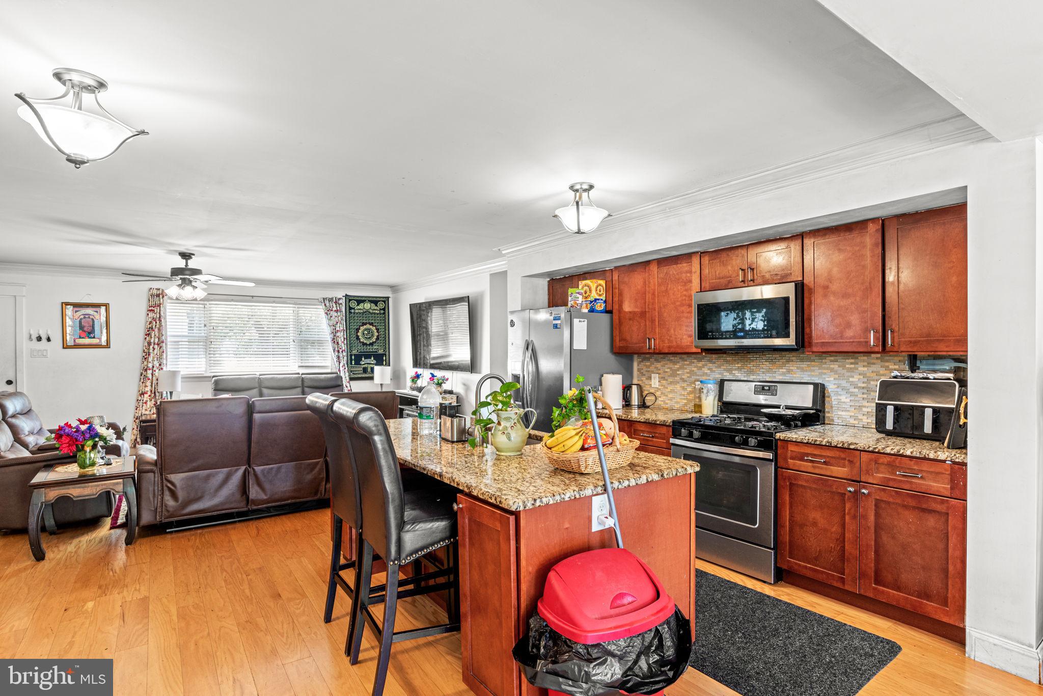 3404 Ridgeway Road Harrisburg, PA 17109 - Photo 10 of 29 a kitchen with stainless steel appliances granite countertop a stove top oven a sink dishwasher a dining table and chairs with wooden floor