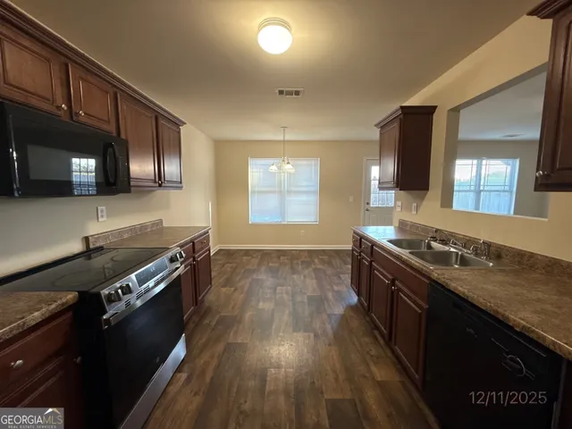 a kitchen with wooden floors and a stove top oven