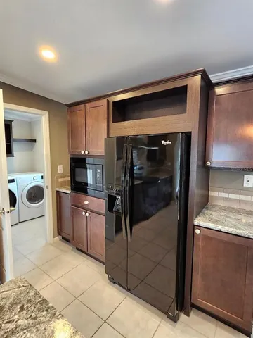 a view of an empty room with a chandelier fan