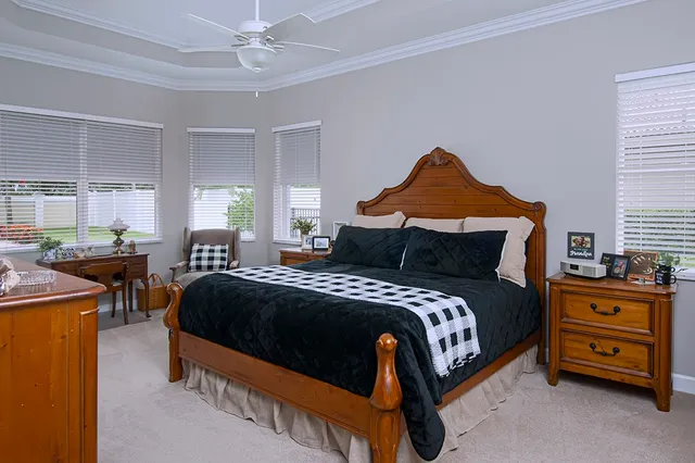 a bedroom with a bed and a dresser next to a window