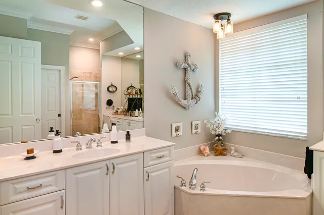 a bathroom with a tub double sink and mirror