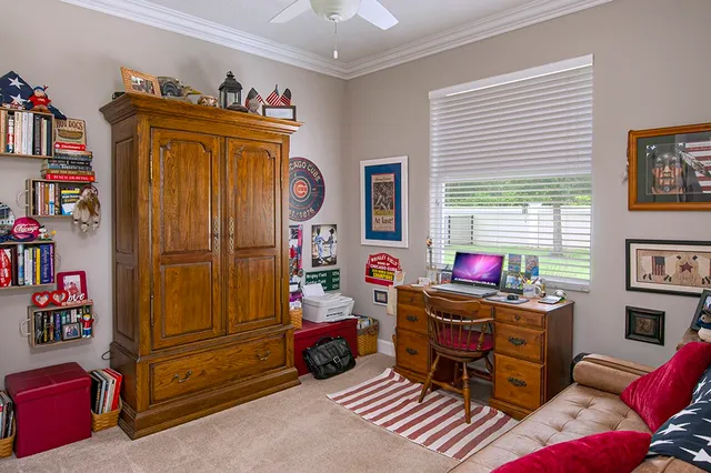 a view of a workspace with furniture and a window