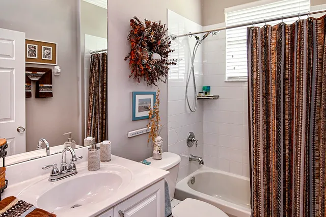 a bathroom with a granite countertop sink a mirror a vanity and shower