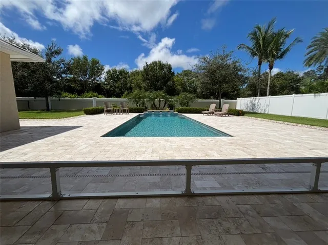 a view of backyard with swimming pool and seating