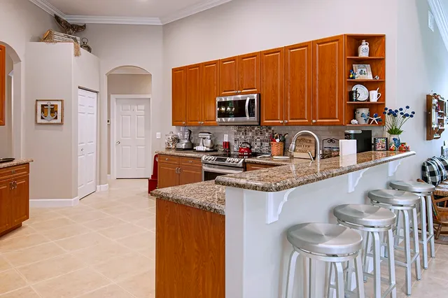 a kitchen with stainless steel appliances granite countertop a sink and a refrigerator