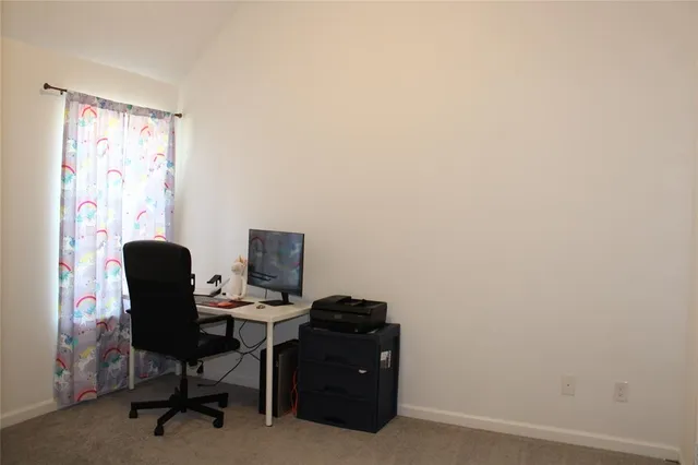 a view of a workspace with furniture and a window