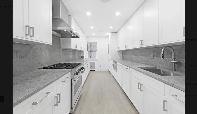 a large kitchen with stainless steel appliances granite countertop a lot of counter space and wooden floors