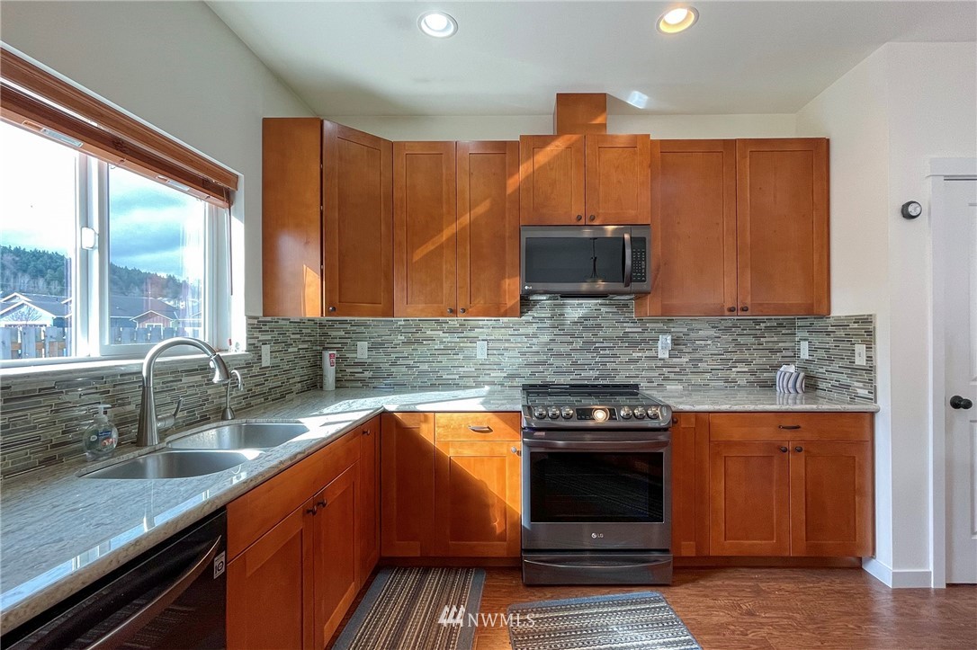20 Stratus Loop Sequim, WA 98382 - Photo 6 of 40 a kitchen with stainless steel appliances a stove a sink and a microwave