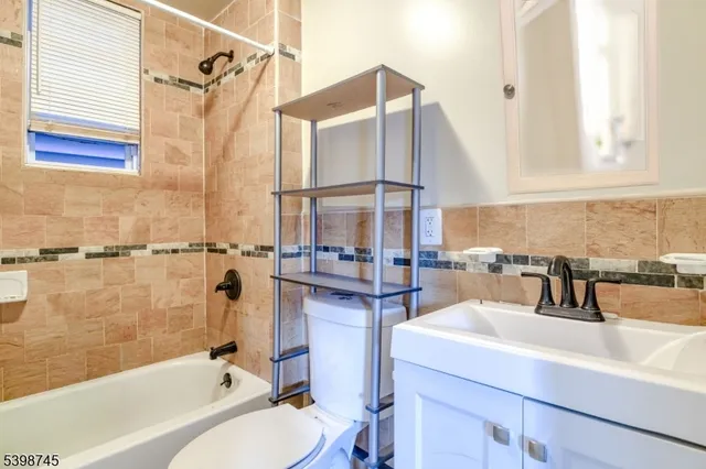 a bathroom with a sink and mirror with bathtub