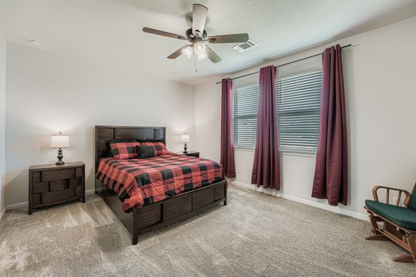 148 Gullivers Drive Elgin, TX 78621 - Photo 9 of 21 a spacious bedroom with a bed and a chandelier