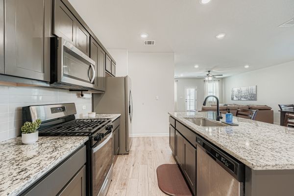 148 Gullivers Drive Elgin, TX 78621 - Photo 21 of 21 a kitchen with stainless steel appliances granite countertop a sink stove and refrigerator