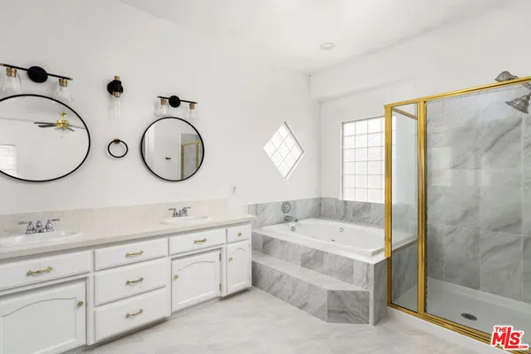 a bathroom with a double vanity sink mirror bathtub and shower