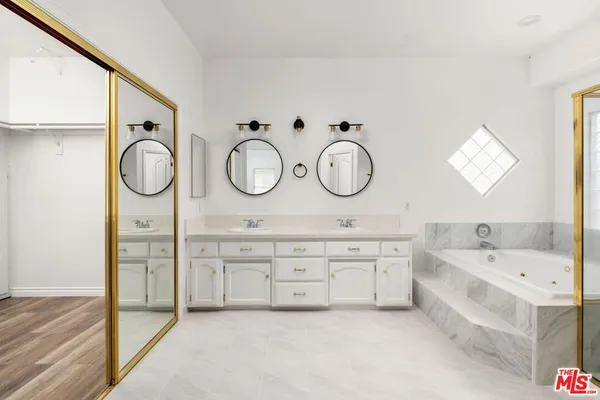 a spacious bathroom with a double vanity sink and a bathtub