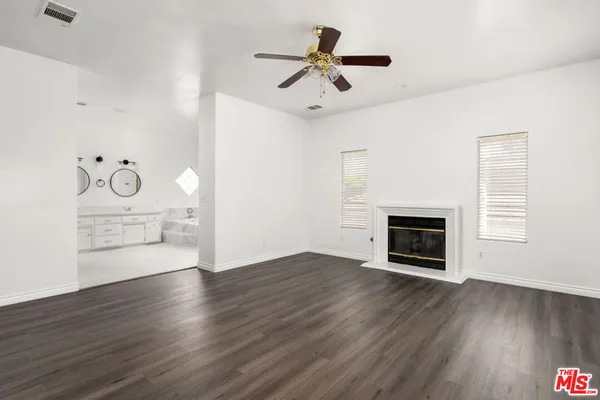 a view of empty room with wooden floor and fireplace