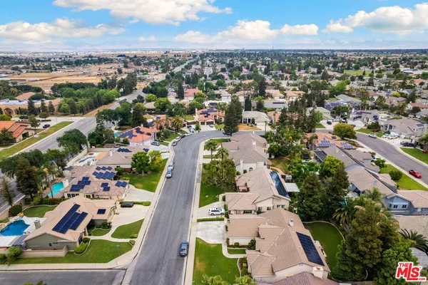 an aerial view of residential houses with outdoor space and trees