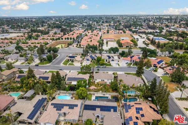 an aerial view of residential houses with outdoor space and swimming pool