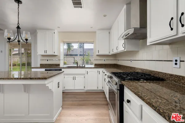 a kitchen with granite countertop stainless steel appliances sink and cabinets