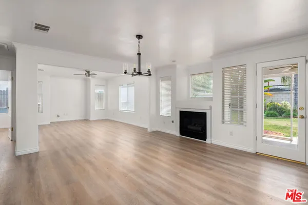 a view of empty room with wooden floor and fireplace