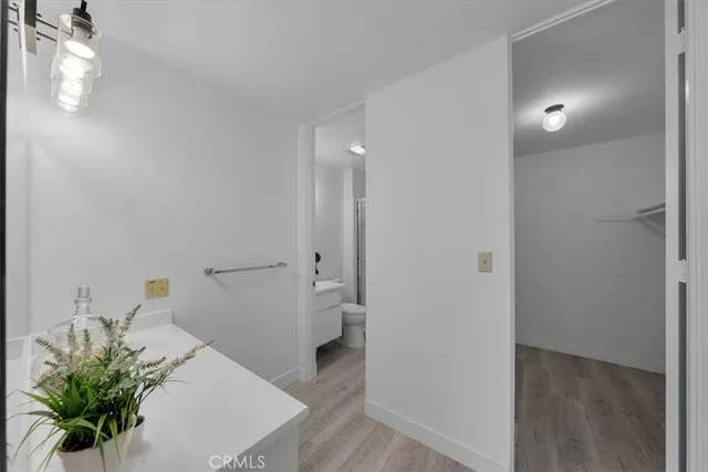 a view of a hallway to a room with wooden floor