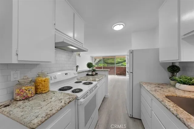 a kitchen with a stove a refrigerator and a sink