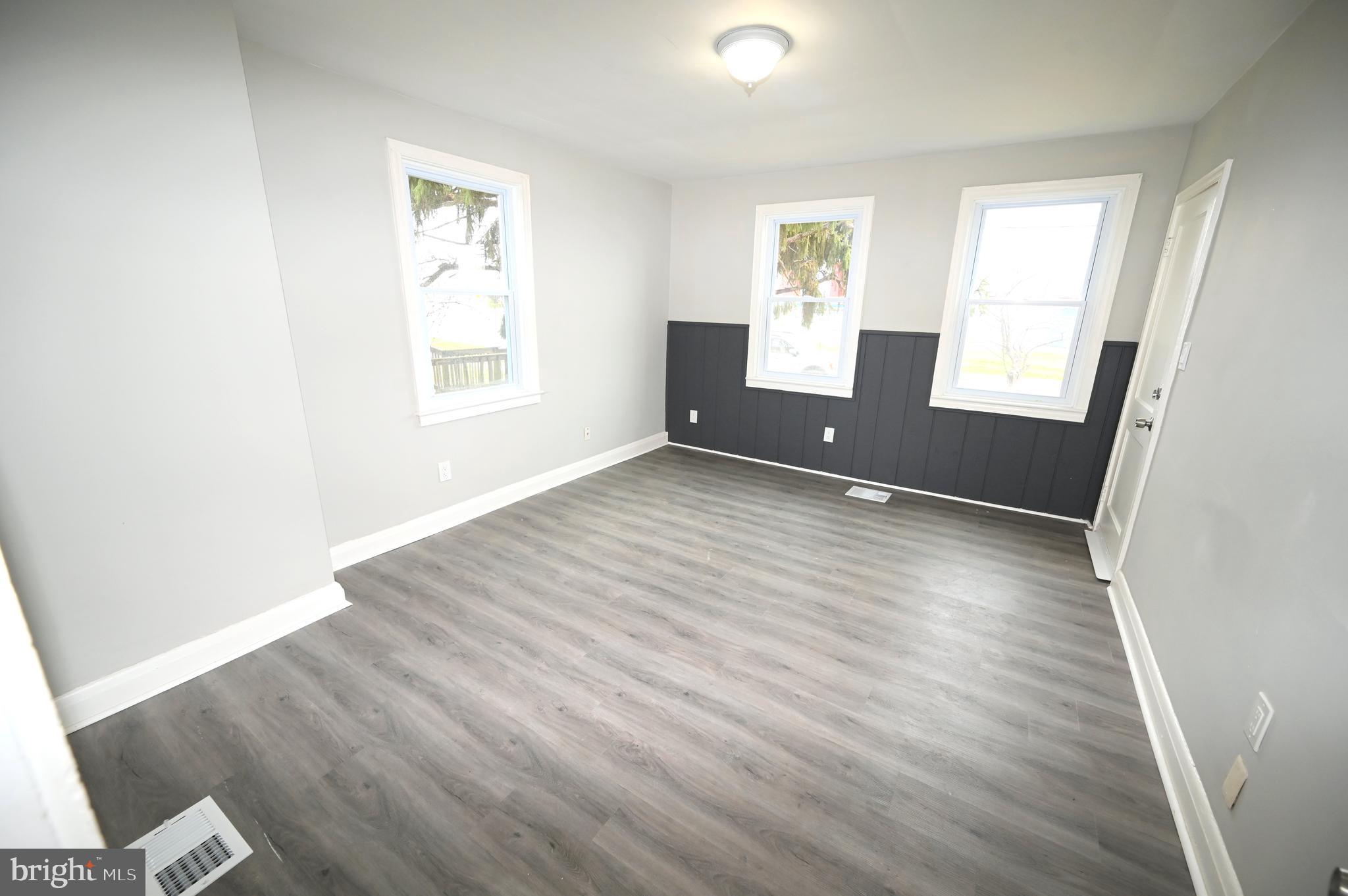 2952 Sollers Point Road, Unit B Dundalk, MD 21222 - Photo 12 of 37 an empty room with wooden floor and windows