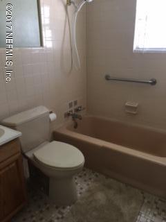 4724 Dundee Road Jacksonville, FL 32210 - Photo 7 of 16 a white toilet sitting next to a bath tub