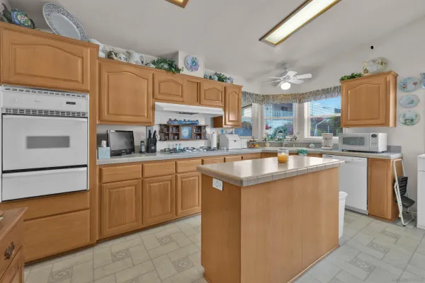 a kitchen with stainless steel appliances granite countertop a sink counter space cabinets and a large window