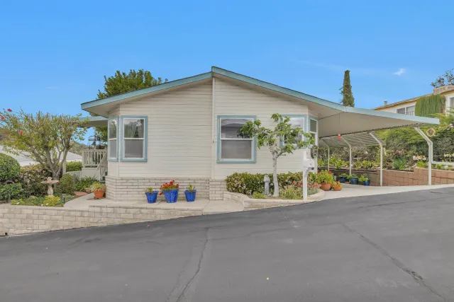 a view of a house with a yard and potted plants