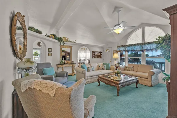 a living room with furniture a fireplace and a chandelier