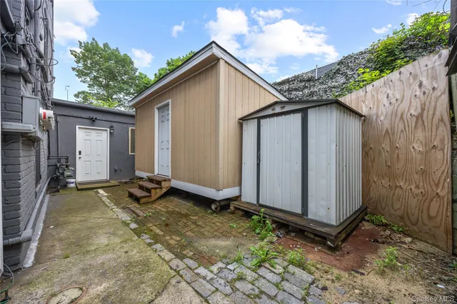 a backyard of a house with plants and wooden fence