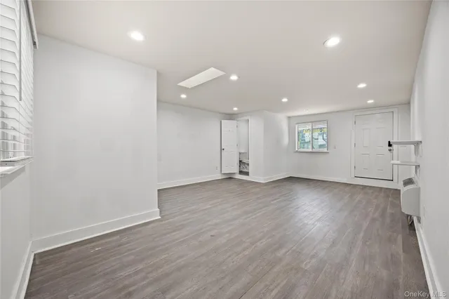 an empty room with wooden floor & closet area