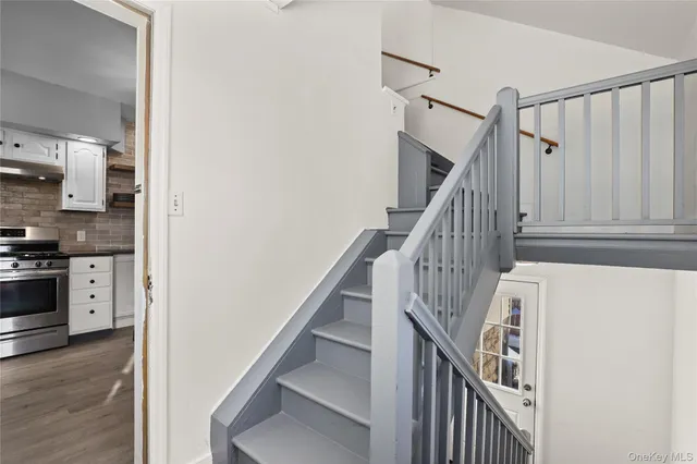 a view of entryway and kitchen with wooden floor