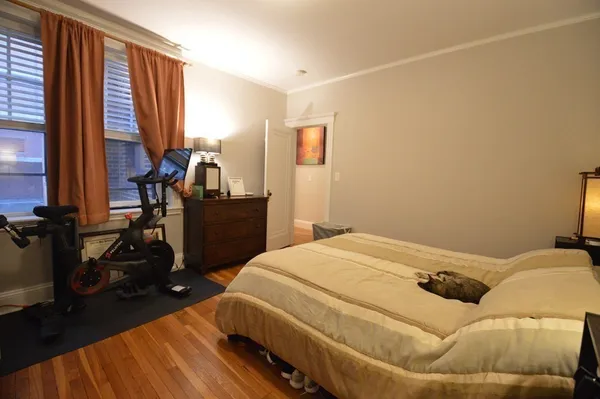 a bedroom with a bed and wooden floor