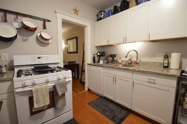 a kitchen with a stove a sink and cabinets