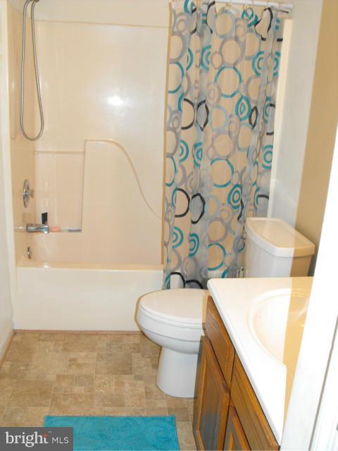 145 Cove Point Road Lusby, MD 20657 - Photo 12 of 13 a bathroom with a sink a toilet and shower curtain