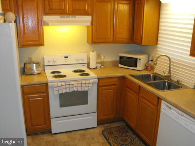 145 Cove Point Road Lusby, MD 20657 - Photo 5 of 13 a kitchen with a sink stove and microwave
