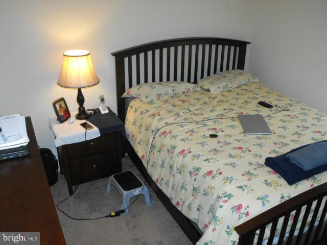 145 Cove Point Road Lusby, MD 20657 - Photo 8 of 13 a bedroom with a bed and a lamp