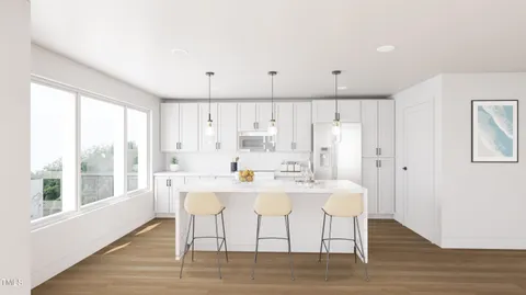 a kitchen with stainless steel appliances kitchen island wooden floors and white cabinets