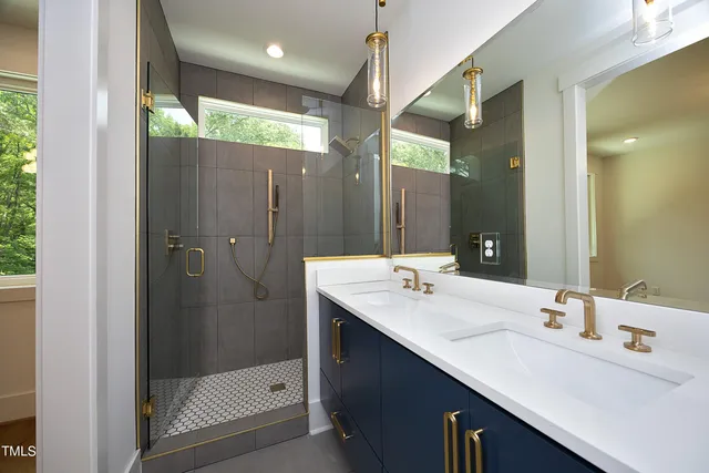 a bathroom with a double vanity sink mirror and shower