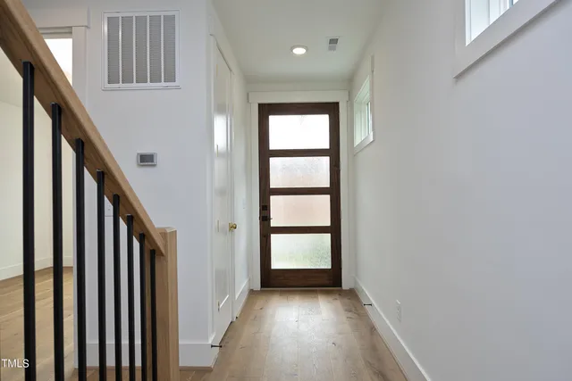 a view of a hallway with wooden floor and stairs