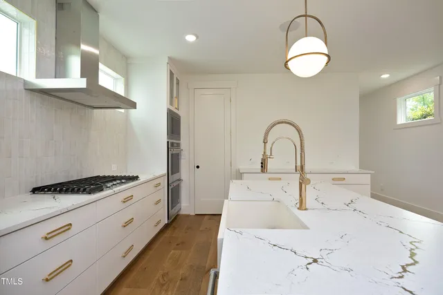 a kitchen with stainless steel appliances kitchen island a white counter space and a sink