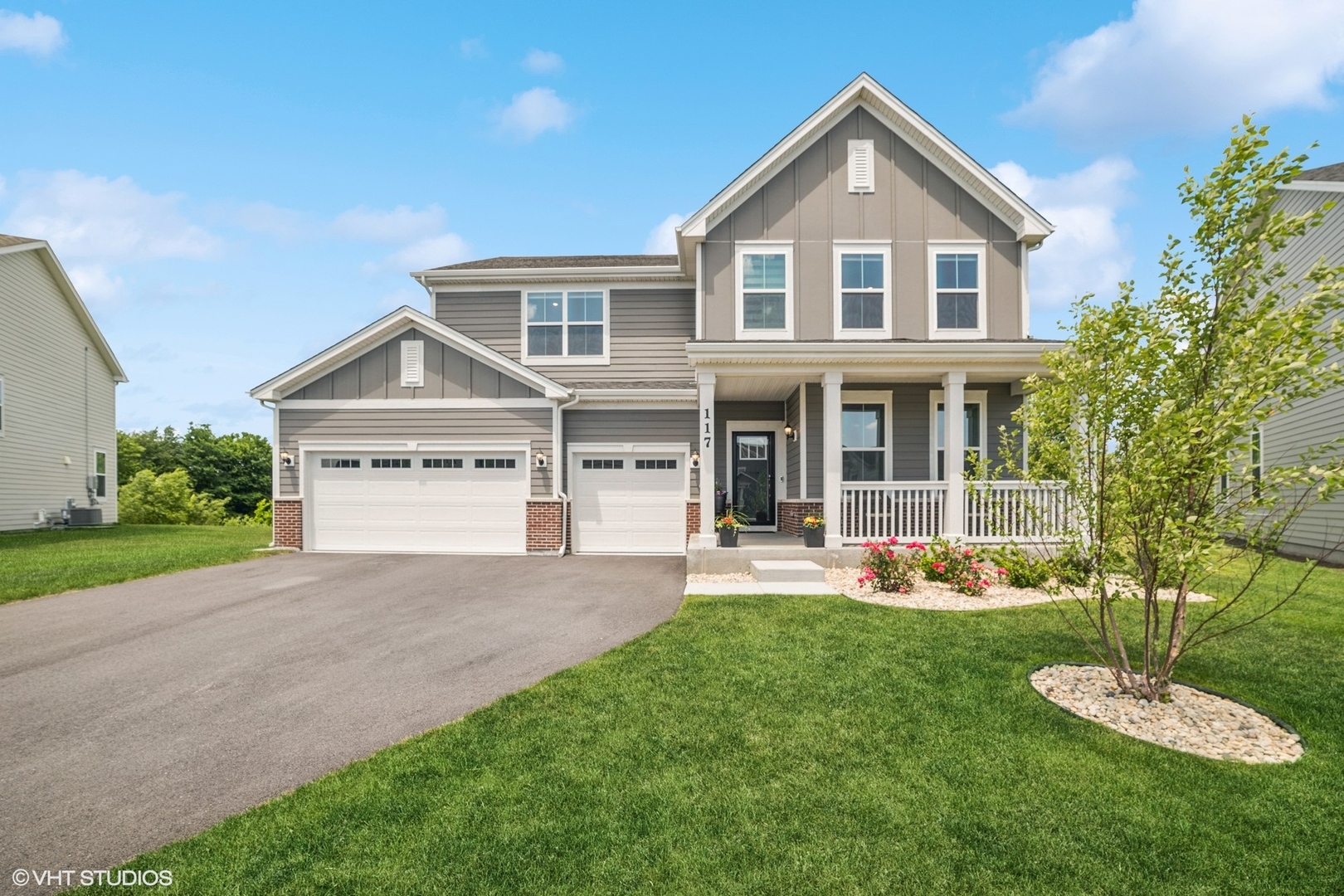 a front view of a house with a yard and trees