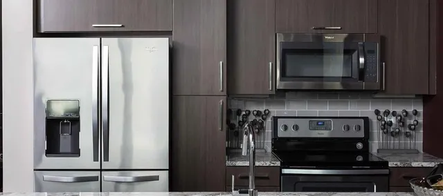 a kitchen with stainless steel appliances granite countertop a stove and a microwave