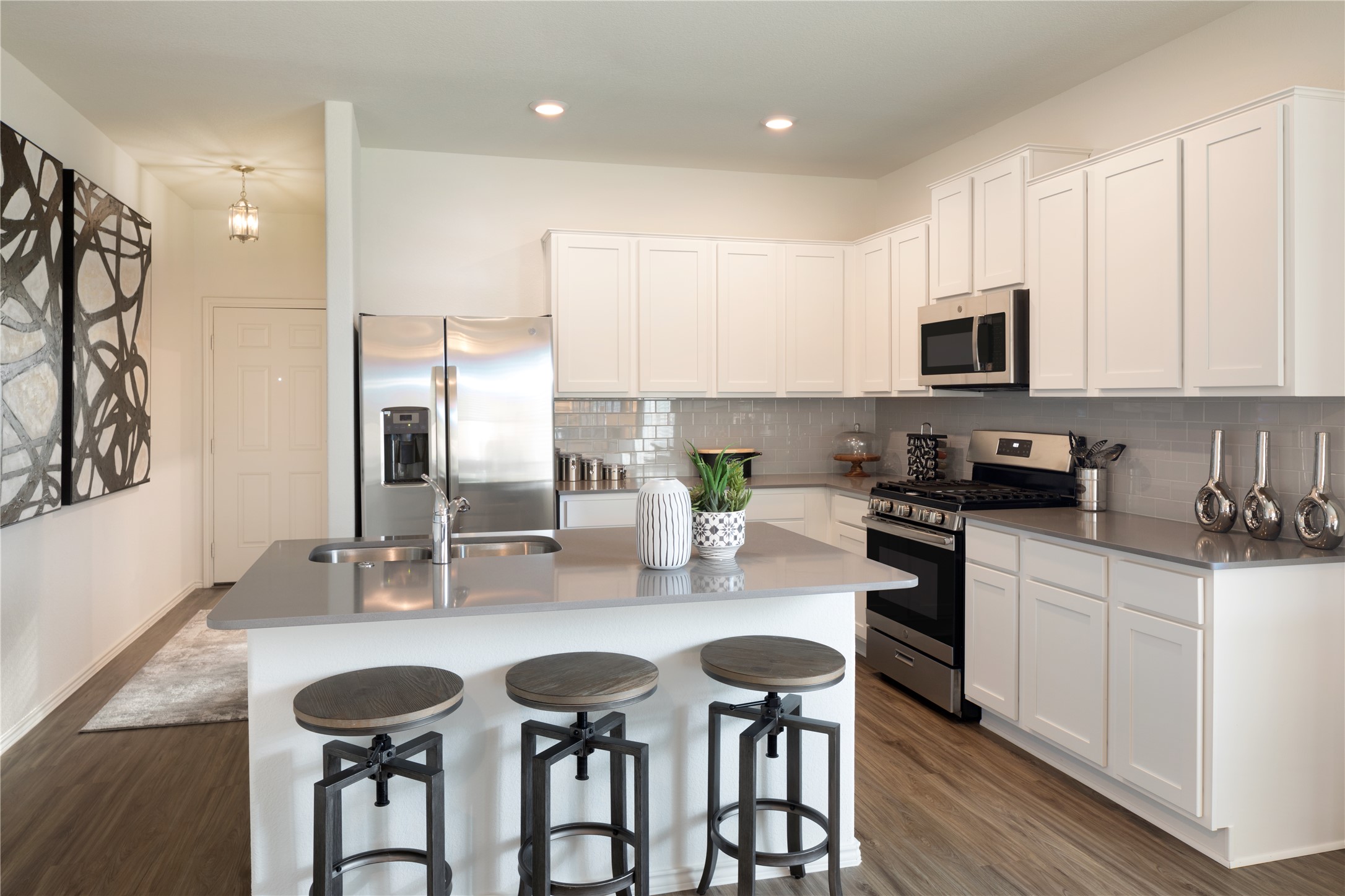 17902 Nashville Warbler Road Pflugerville, TX 78660 - Photo 10 of 17 a kitchen with stainless steel appliances kitchen island granite countertop a sink and cabinets