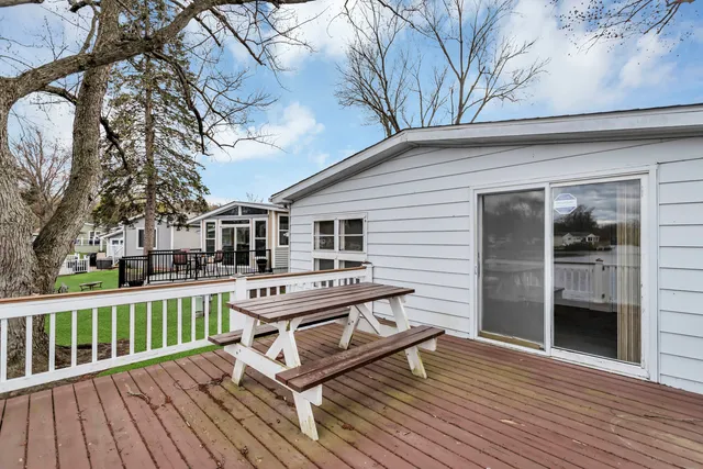 a balcony with wooden floor table and chairs